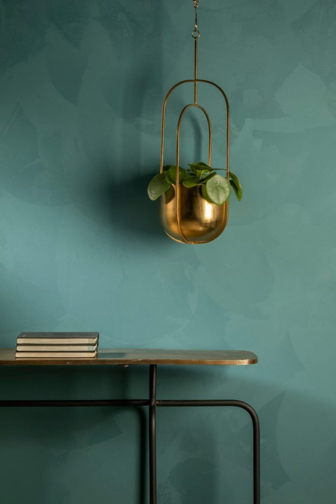 decorativo sikkens color petrolio con console libri e vaso appeso