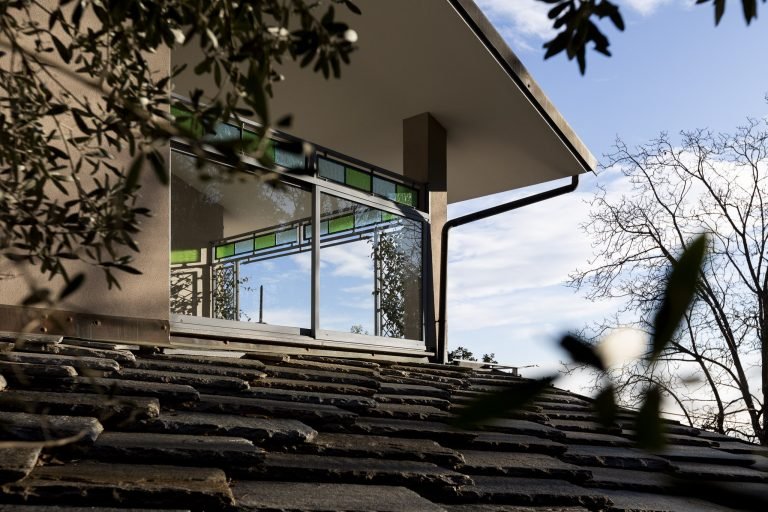 detail of villa with big window and trees in front