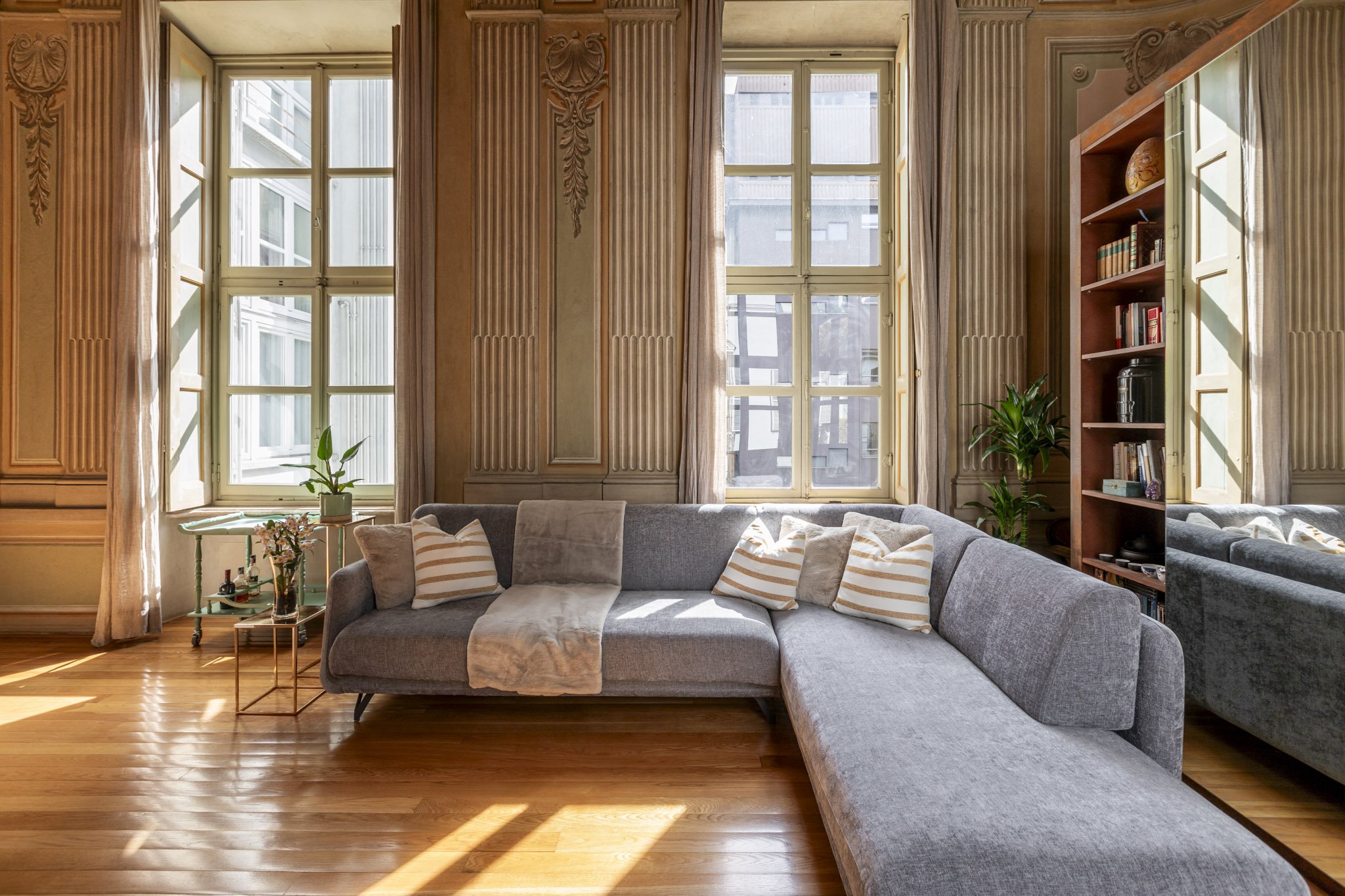zona giorno con grande sofa grigio in un appartamento d'epoca